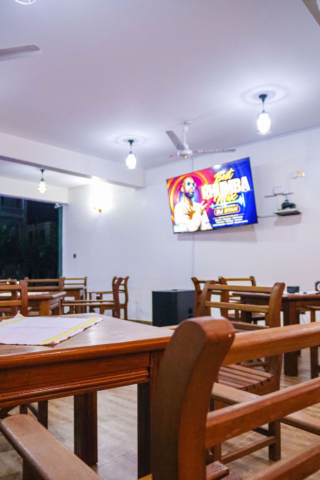 Restaurant tables with a television in the background
