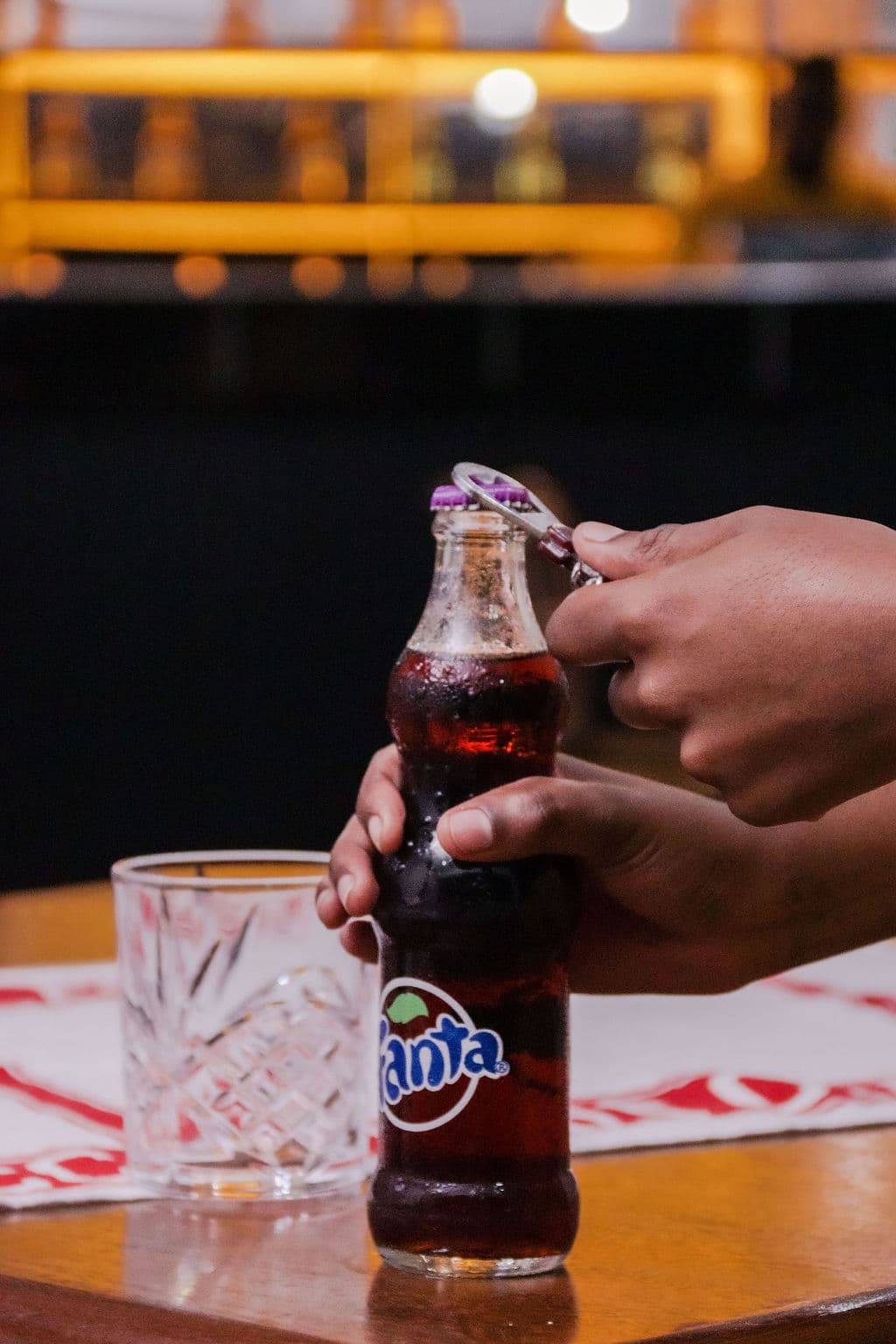 A hand opening a cold drink at a restaurant table