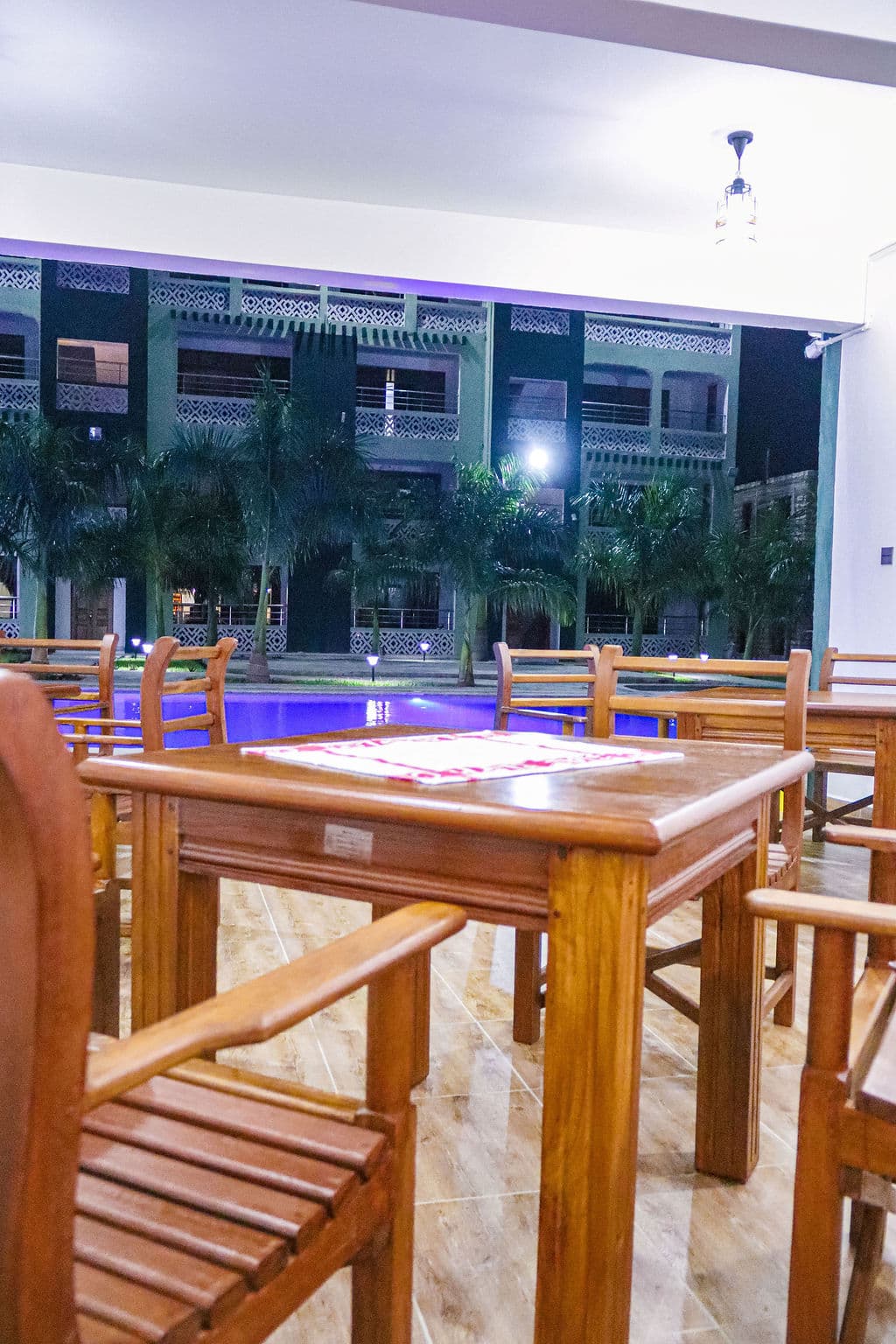 Restaurant tables beside the pool after dark